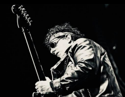 Neal Schon Play Guitar with a black backdrop