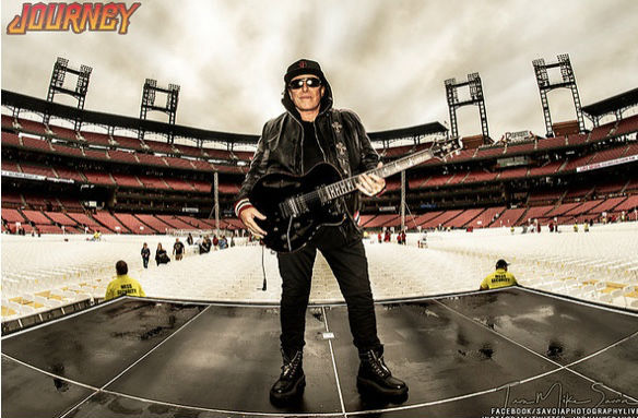 Neal Schon center stage Stadium with black hoodie